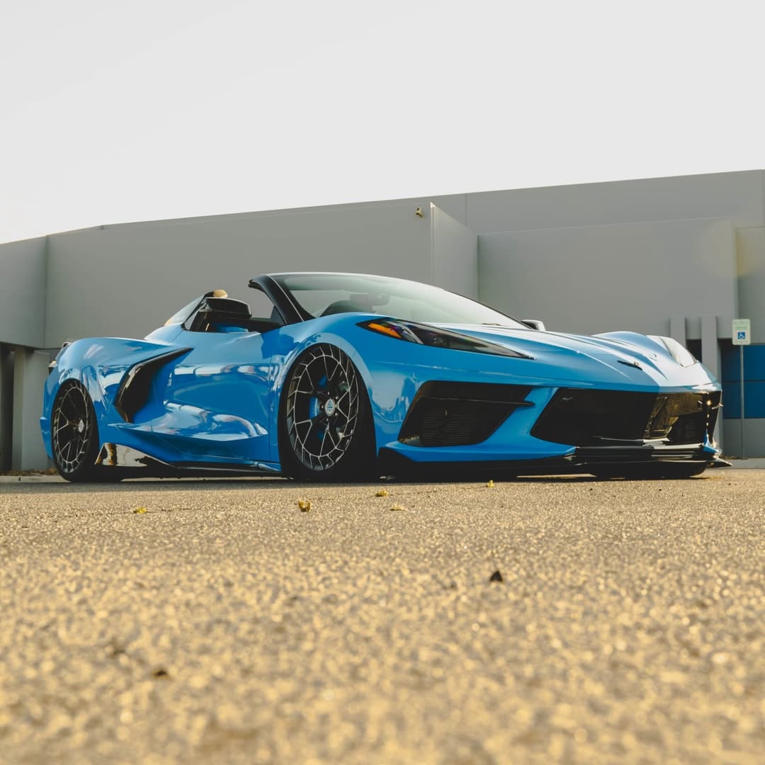 Custom blue Corvette C8 convertible showcasing forged aftermarket rims on a sunny day.