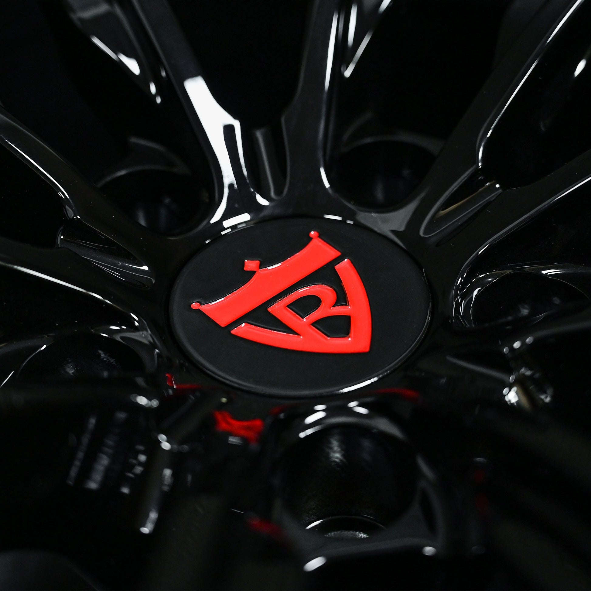 Close-up of custom forged black Corvette C6 Z06 wheel with red logo detail