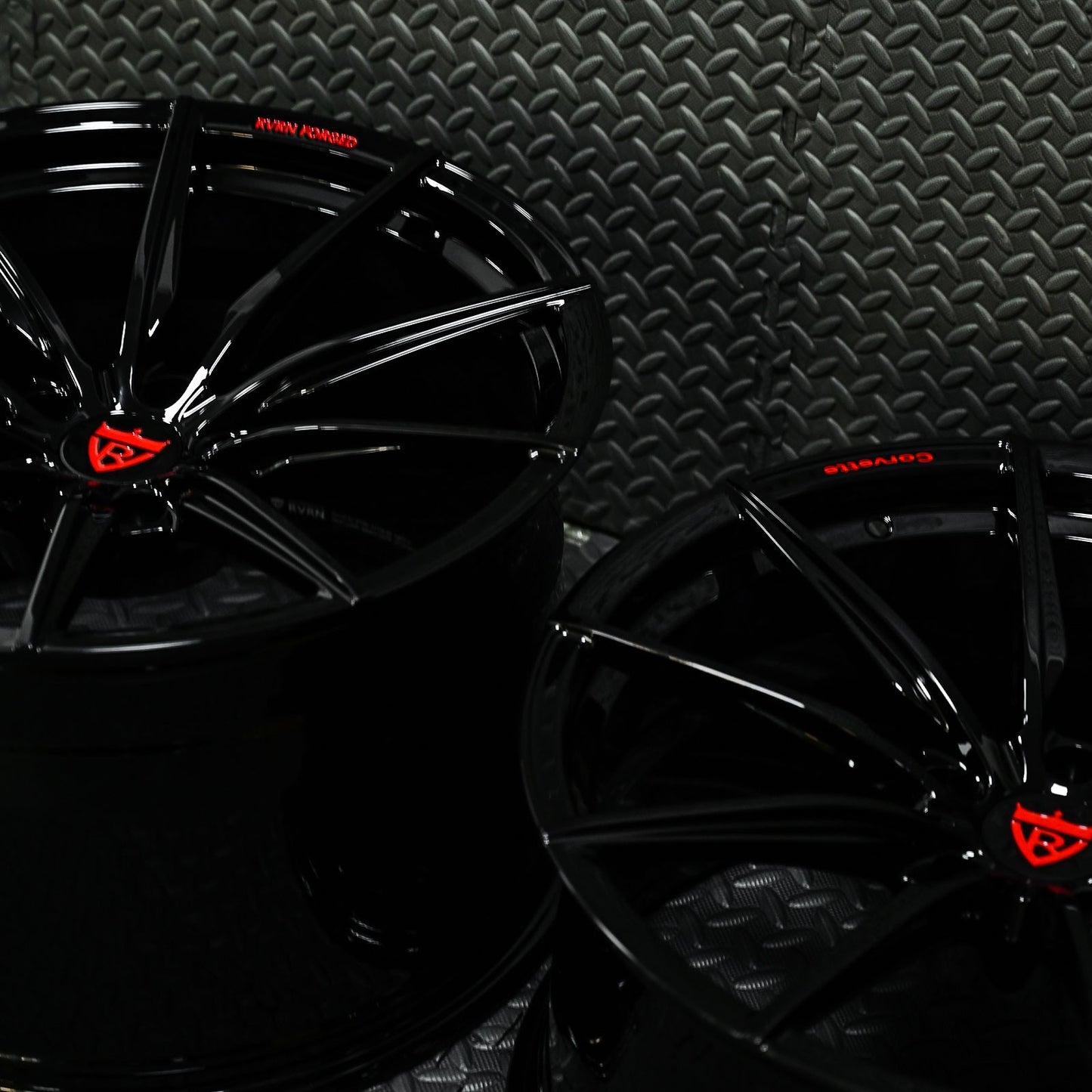 Glossy black custom forged Corvette C6 Z06 wheels with red accents, showcasing a sleek concave design.