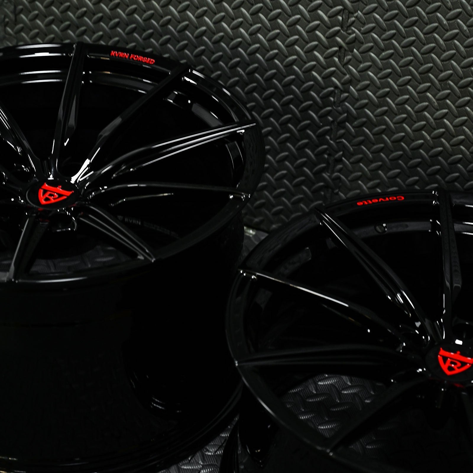 Glossy black custom forged Corvette C6 Z06 wheels with red accents, showcasing a sleek concave design.