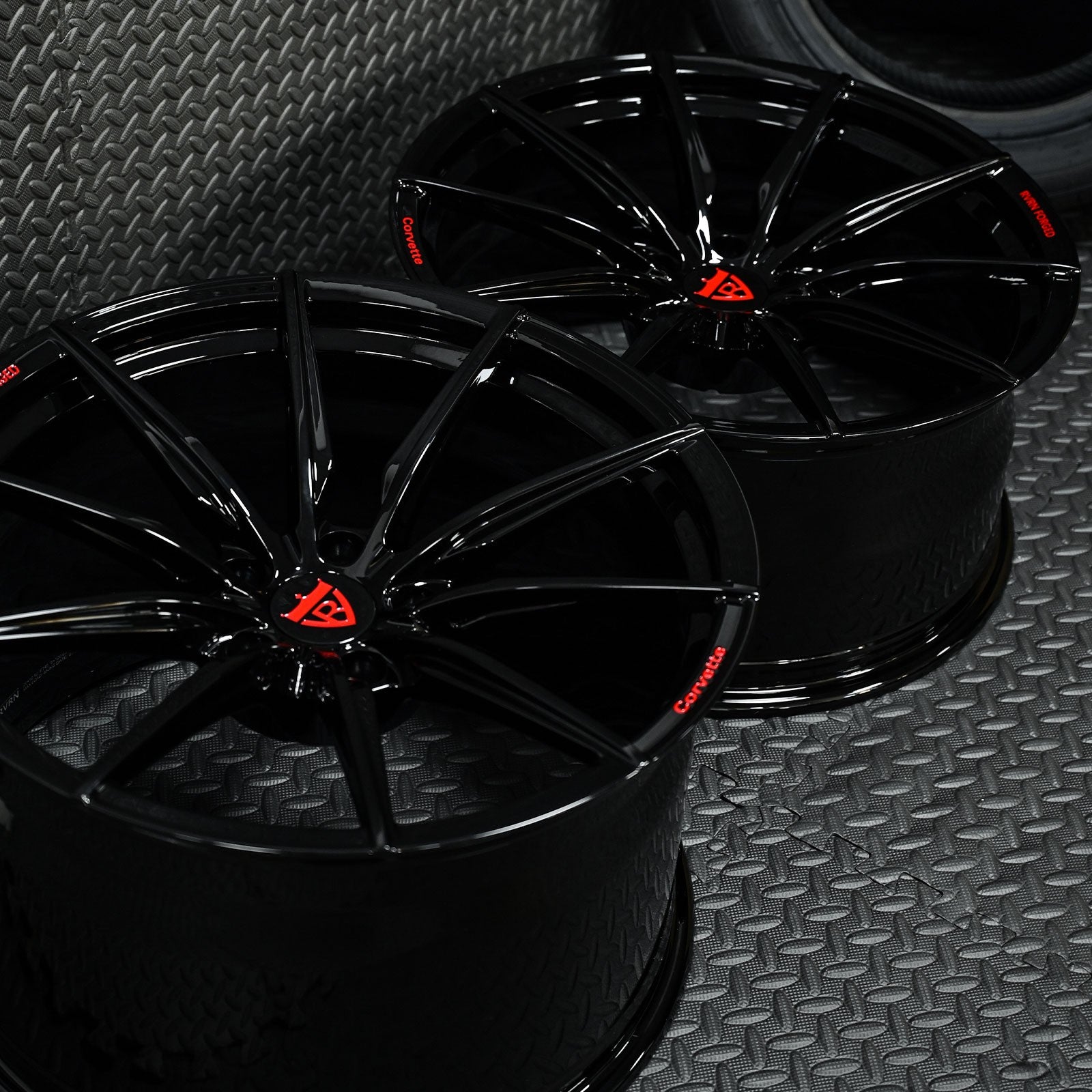 Custom forged Corvette C6 Z06 black wheels with a sleek design and red logo, showcasing high-quality craftsmanship.