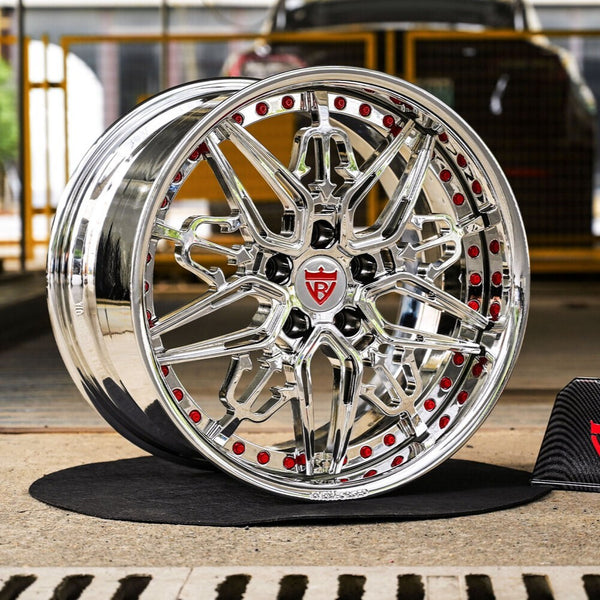 Chrome car wheel with red accents on a blurred background