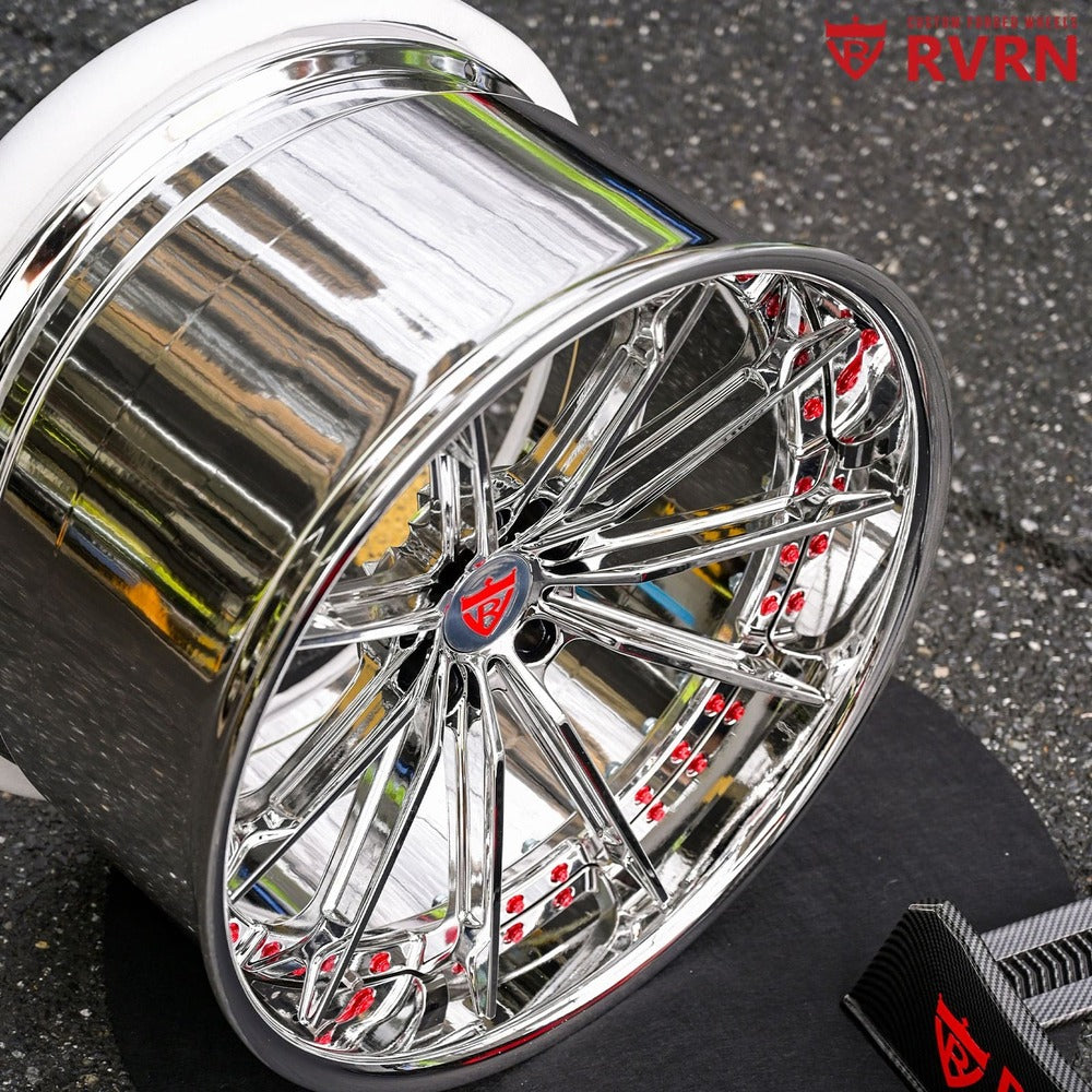 Close-up of red hardware against chrome wheel surface