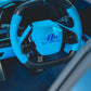 Custom blue steering wheel with carbon fiber details in a luxury car interior.