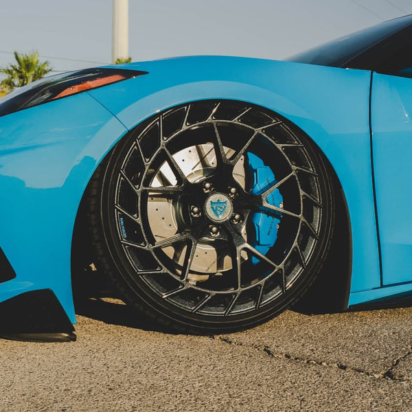 Corvette C8 with custom forged carbon flash wheels showcasing a sleek blue exterior and performance brake calipers.